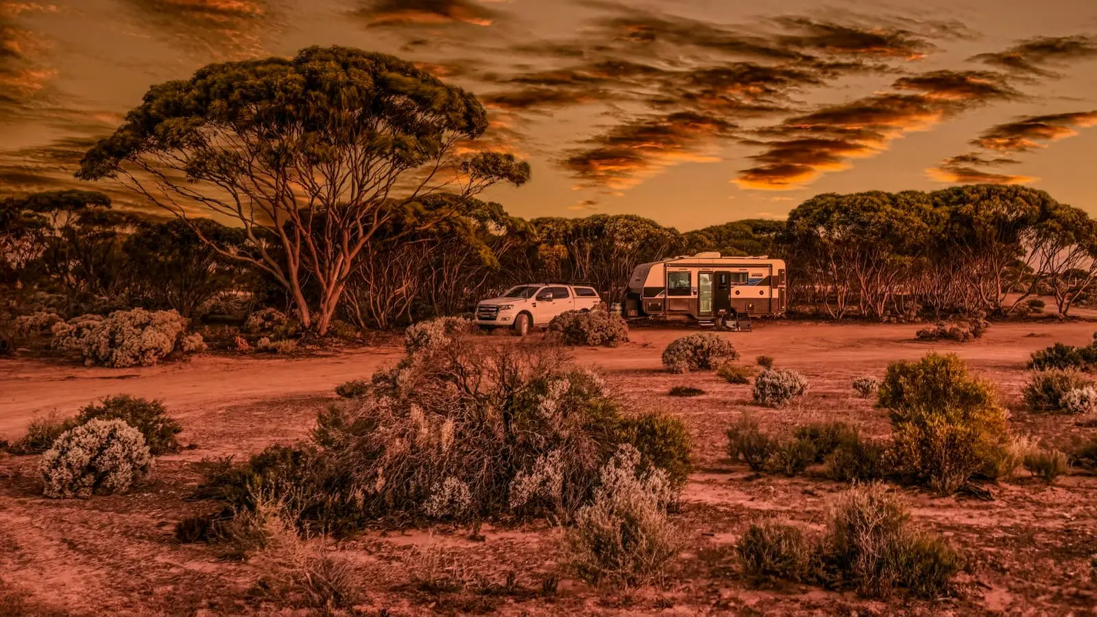Four-wheel drive vehicle parked on red outback sand near the coast in Australia