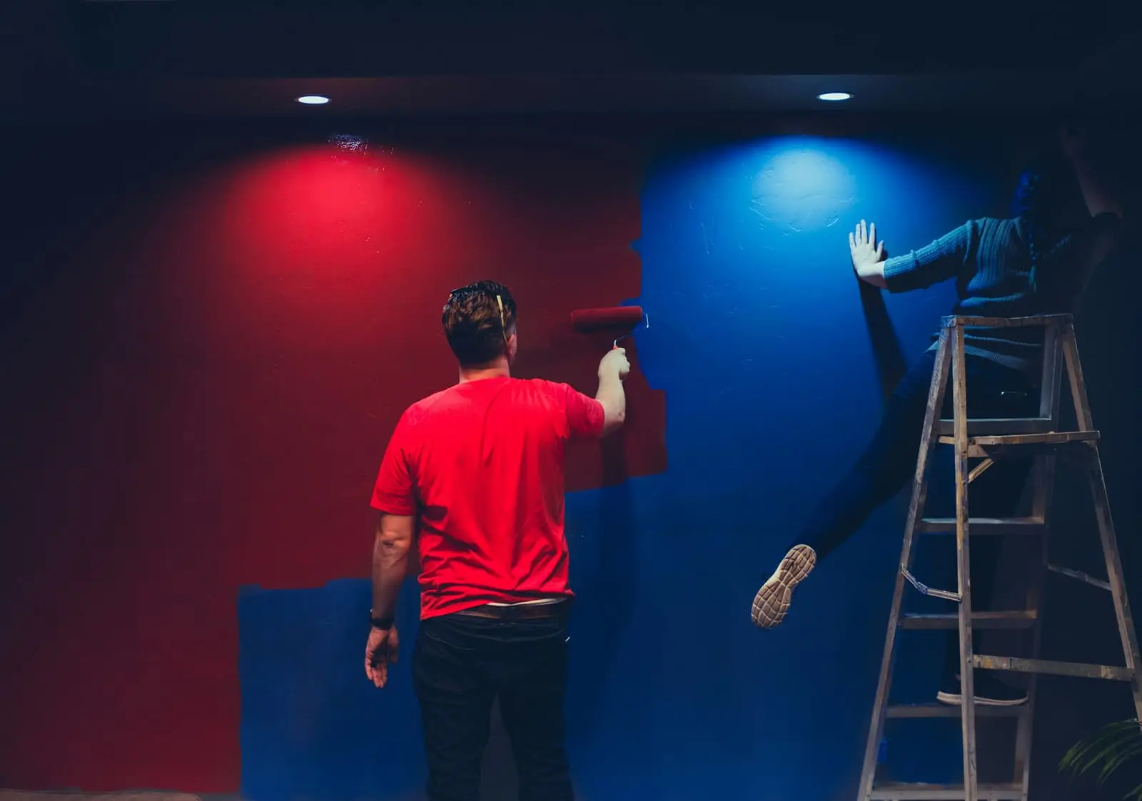 Man and woman painting a wall together during a home renovation