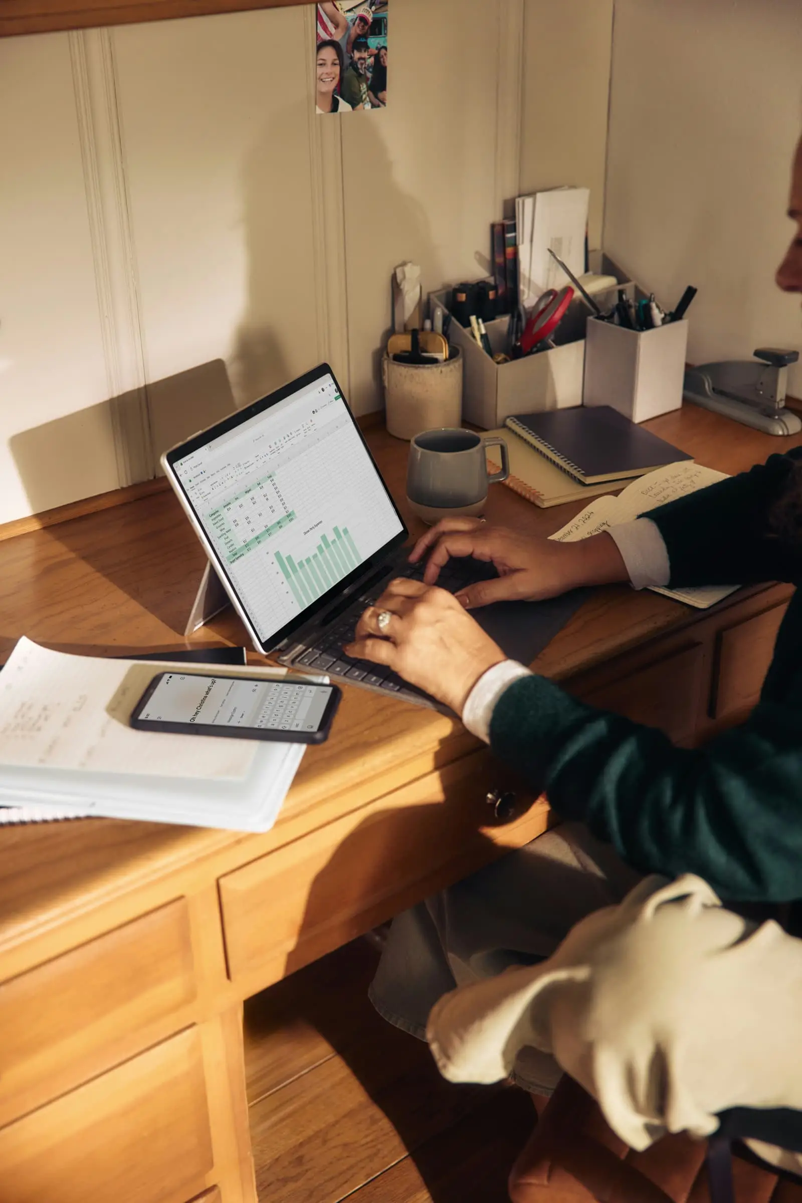 Person working on a laptop at a wooden desk