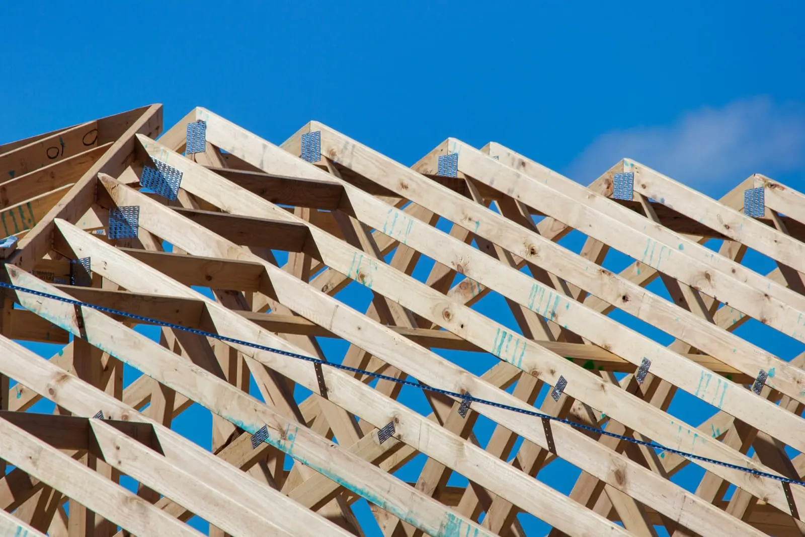 Timber frame structure of a house under construction against a blue sky