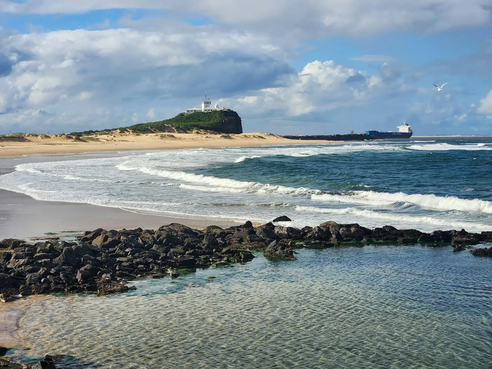 Nobbys Beach at Newcastle with a lighthouse in the distance