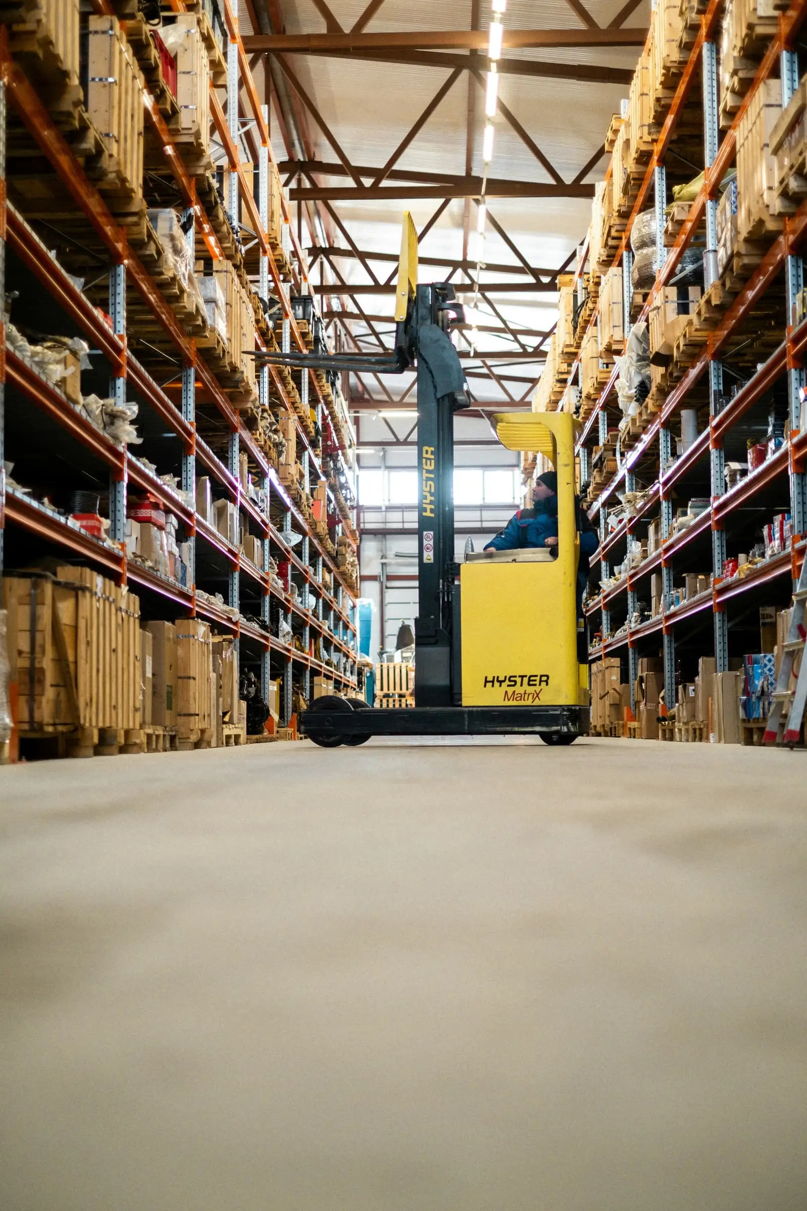 Yellow forklift parked in a large warehouse with stacked shelving